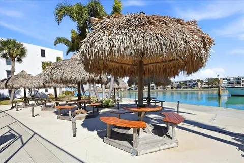 a lake view with table and chairs under an umbrella