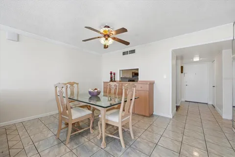 a view of a dining room with furniture and chandelier fan