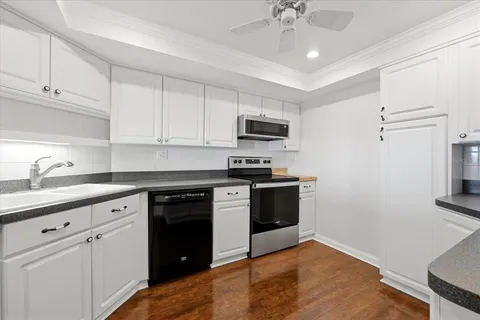 a kitchen with kitchen island granite countertop a sink cabinets and stainless steel appliances