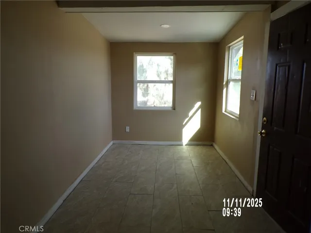 a view of an empty room with window and closet