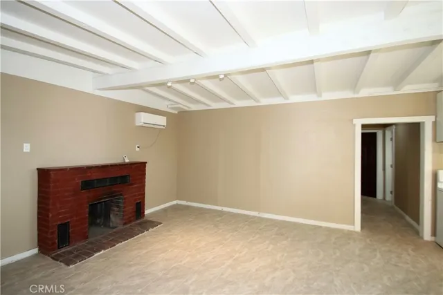 a view of an empty room with a fireplace and a window