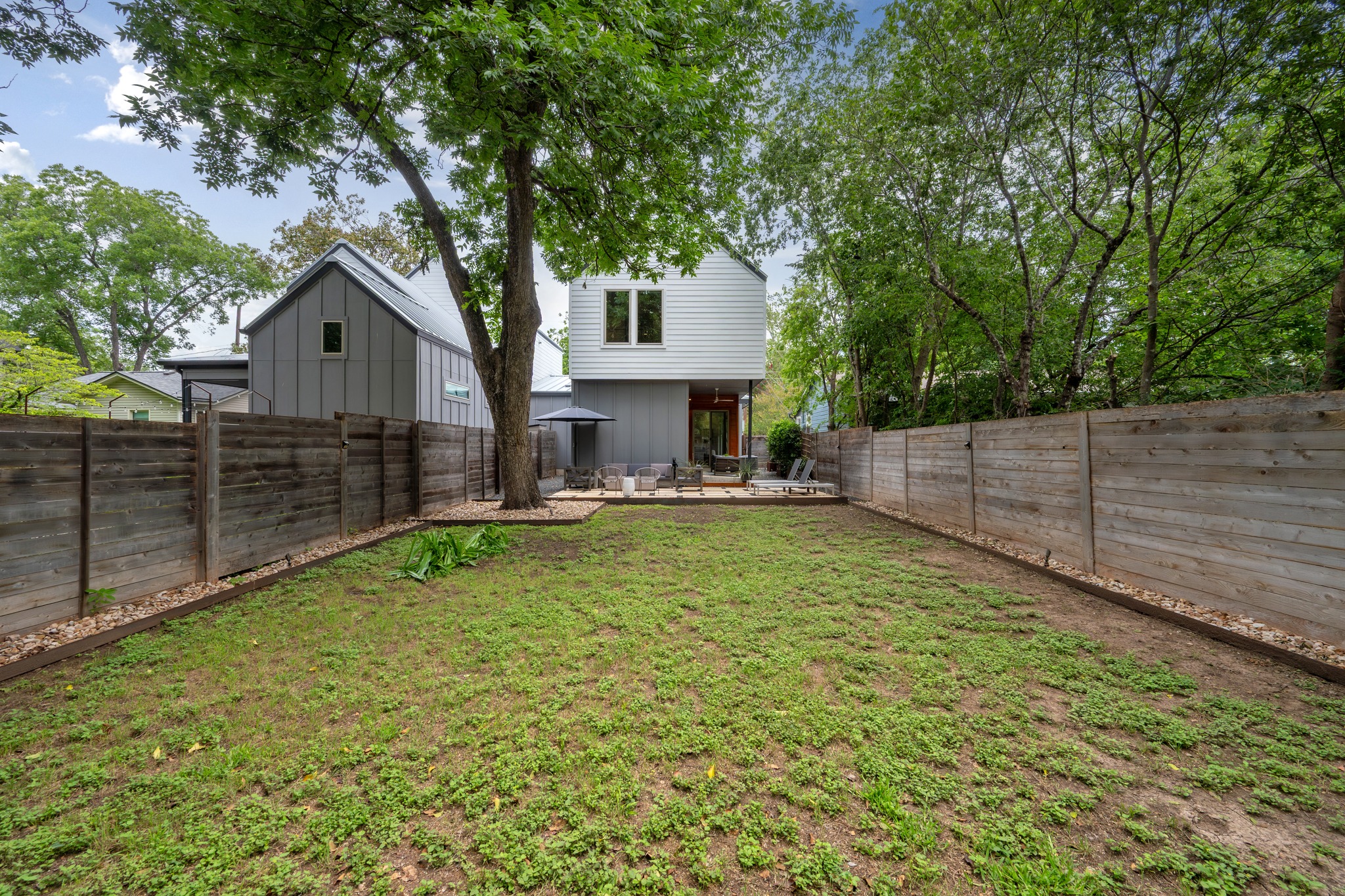 1409 Alegria Road, Unit A Austin, TX 78757 - Photo 23 of 24 A generous lawn and private patio extend from the home's rear, ideal for outdoor leisure.