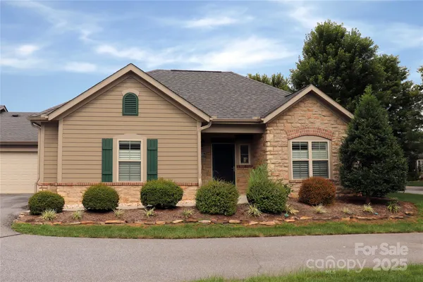 a front view of a house with yard and green space
