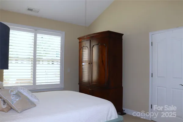 a bedroom with a bed and two windows