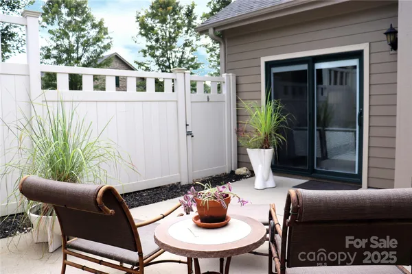 a view of a patio with couple of chairs and a potted plant