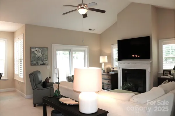 a living room with furniture a fireplace and a flat screen tv