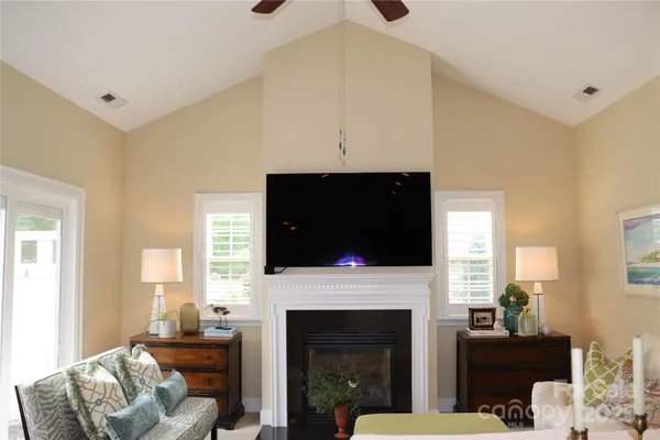 a living room with furniture a flat screen tv and a fireplace