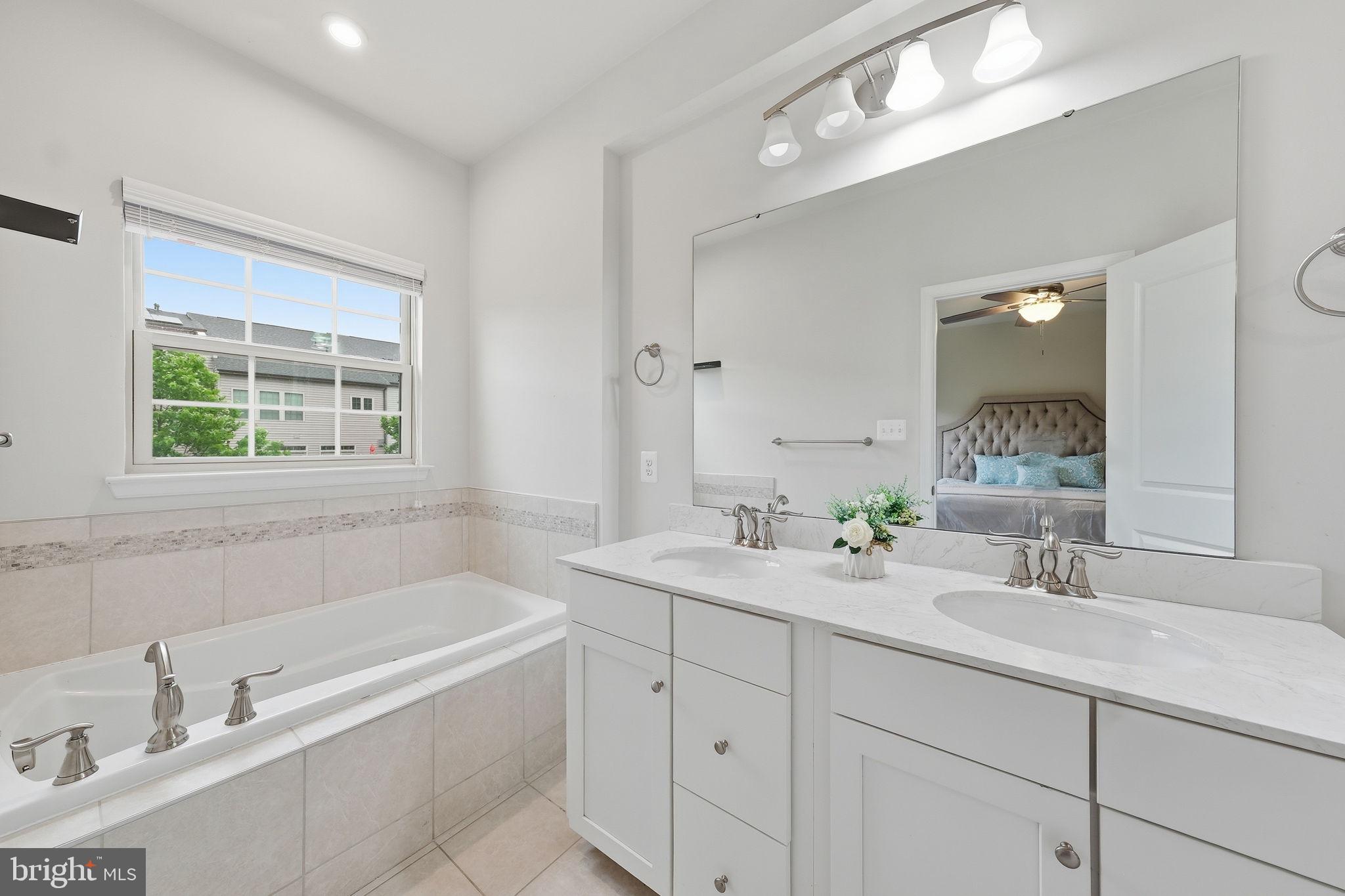 3012 Bretons Ridge Way Hanover, MD 21076 - Photo 21 of 37 a bathroom with a tub a sink double vanity and a mirror