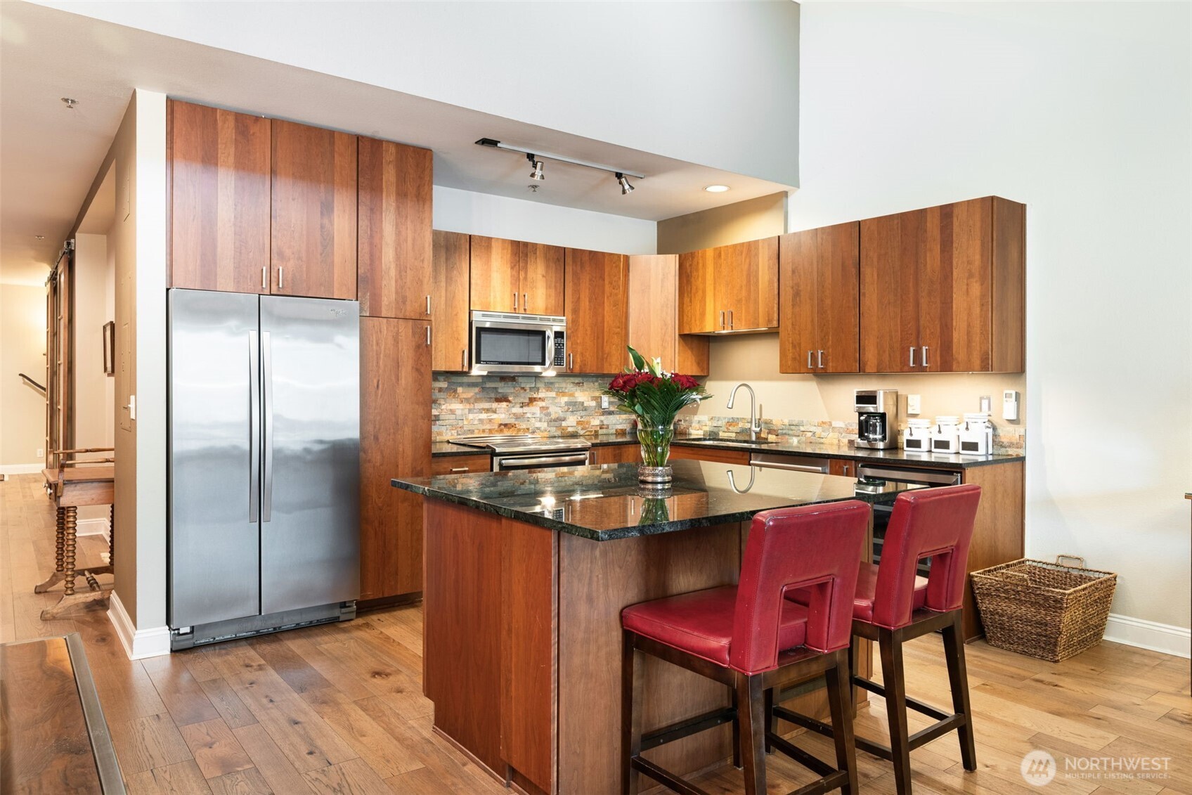 526 1st Avenue South, Unit 511 Seattle, WA 98104 - Photo 15 of 36 a kitchen with stainless steel appliances granite countertop a table chairs sink refrigerator and cabinets