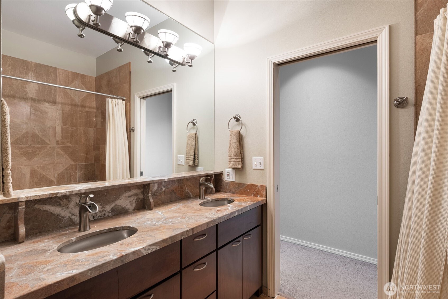 526 1st Avenue South, Unit 511 Seattle, WA 98104 - Photo 24 of 36 a bathroom with a granite countertop sink a large mirror and a shower