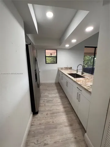 a kitchen with granite countertop a sink and a stove
