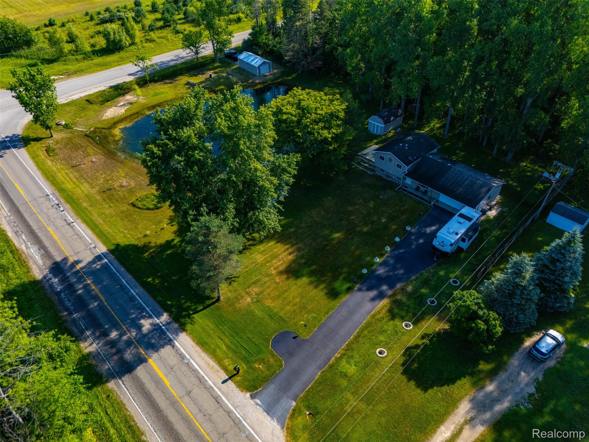 3744 Fish Lake Road Lapeer, MI 48446 - Photo 39 of 50 Expansive property featuring a private pond, mature trees, and a paved driveway