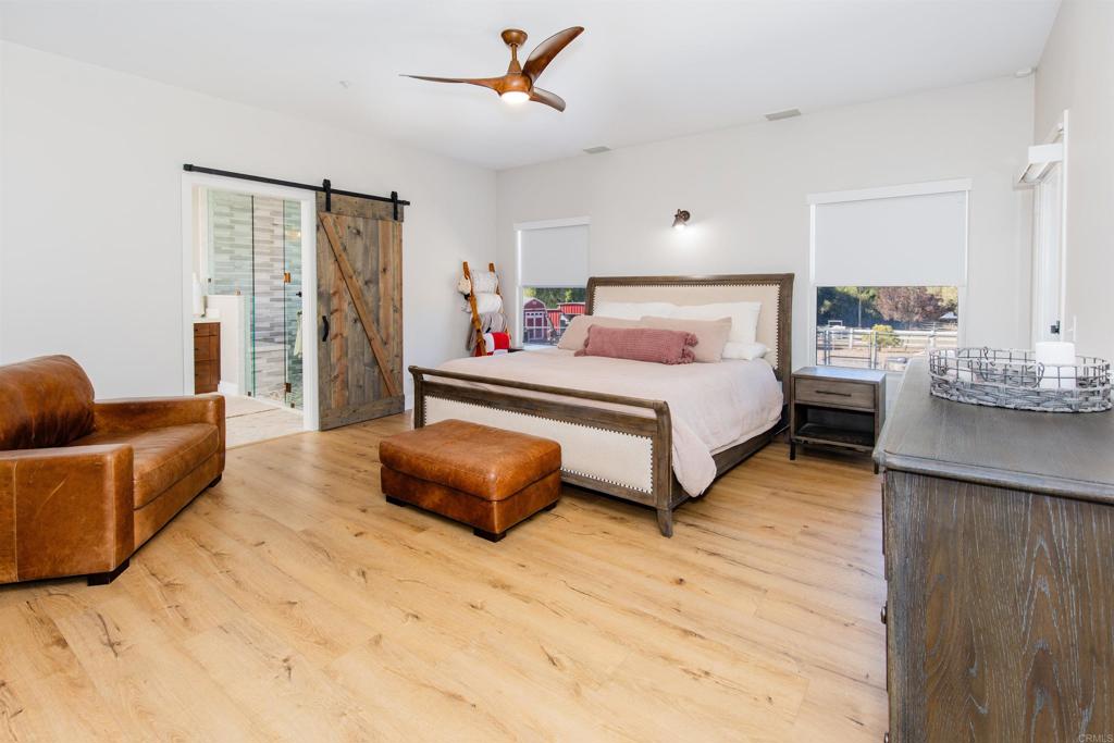 22544 Tombill Road Ramona, CA 92065 - Photo 16 of 74 a spacious bedroom with a bed a couch and a window