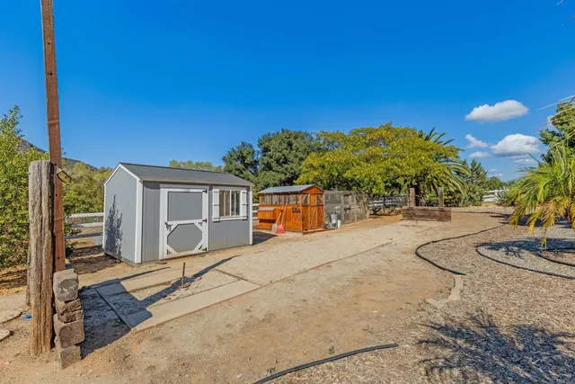 an aerial view of residential houses with outdoor space and trees all around