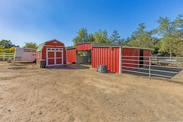 a view of a dry yard with wooden fence