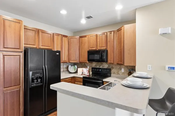 a kitchen with a refrigerator and a stove top oven