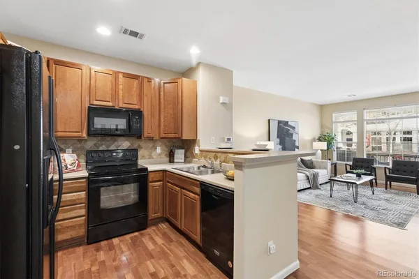 a kitchen with a sink a counter top space stainless steel appliances and cabinets