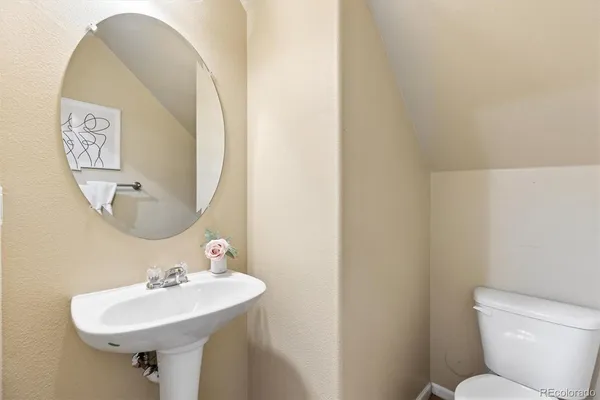 a bathroom with a toilet a sink and mirror