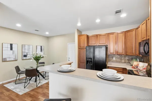 a kitchen with stainless steel appliances kitchen island granite countertop a refrigerator a stove a sink and a dining table with garden view