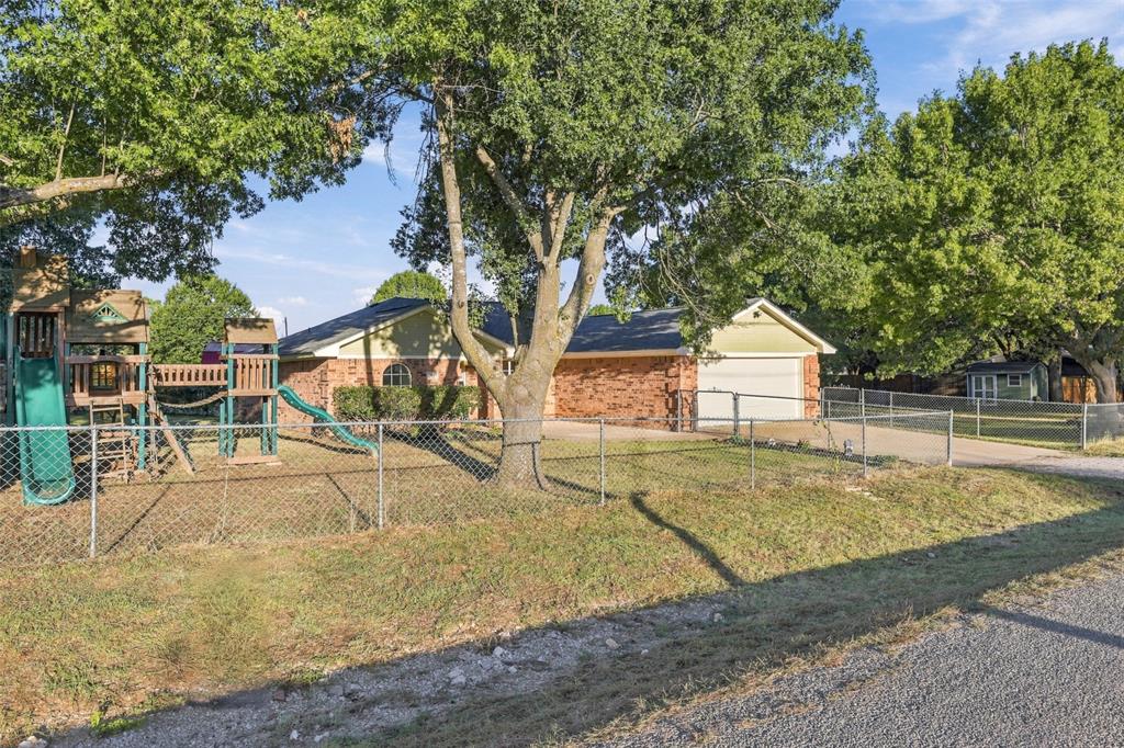 304 Sage Trail Springtown, TX 76082 - Photo 4 of 33 Front Yard – Fully fenced outdoor space with mature shade trees and playground.