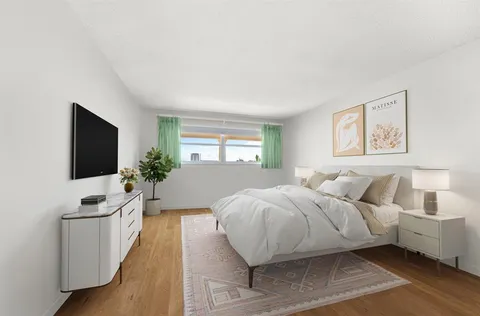 a spacious bedroom with a bed and a flat screen tv
