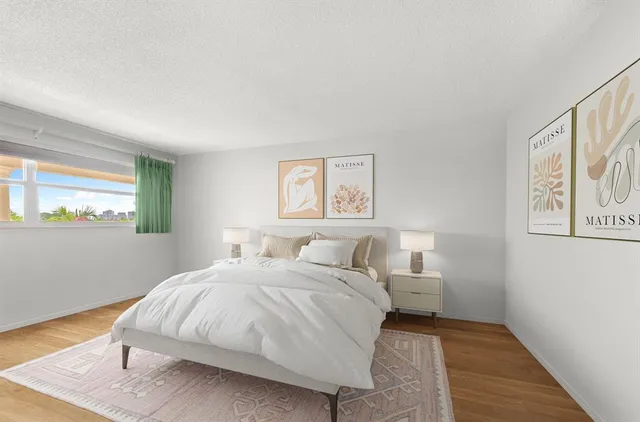 a bedroom with a bed and painting on the wall