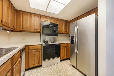 a kitchen with stainless steel appliances granite countertop a refrigerator stove and microwave