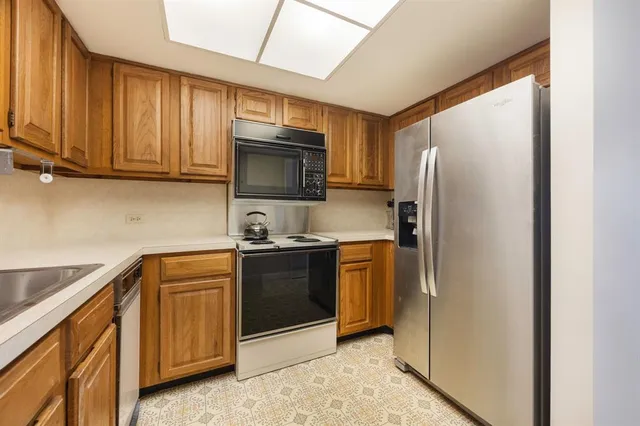 a kitchen with stainless steel appliances granite countertop a refrigerator stove and microwave