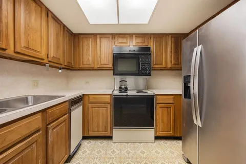 a kitchen with stainless steel appliances granite countertop a refrigerator stove and microwave