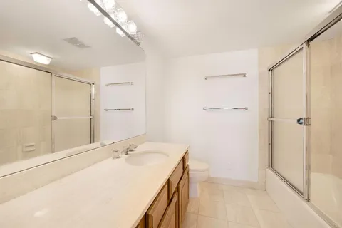 a bathroom with a granite countertop sink a shower and a mirror