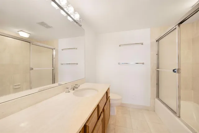 a bathroom with a granite countertop sink a shower and a mirror