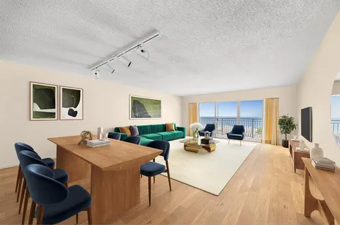 a living room with furniture a flat screen tv and a table