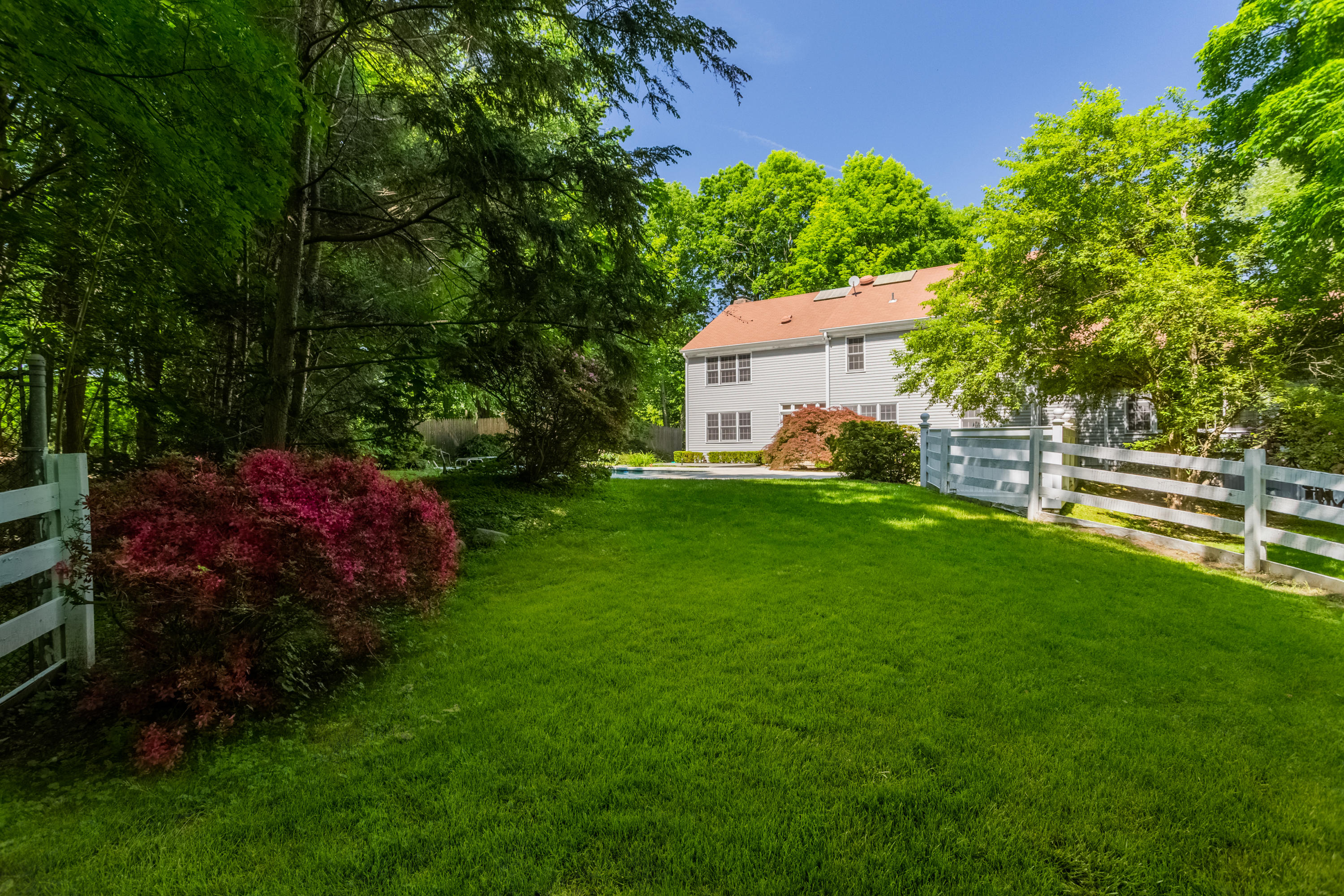 36 Locust Hill Road Darien, CT 06820 - Photo 34 of 40 a view of a garden with a house in the background