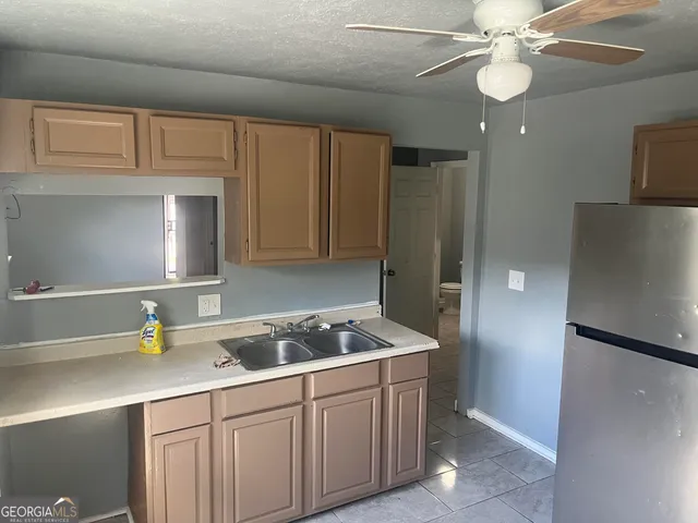 a kitchen with stainless steel appliances granite countertop a sink a stove and a refrigerator