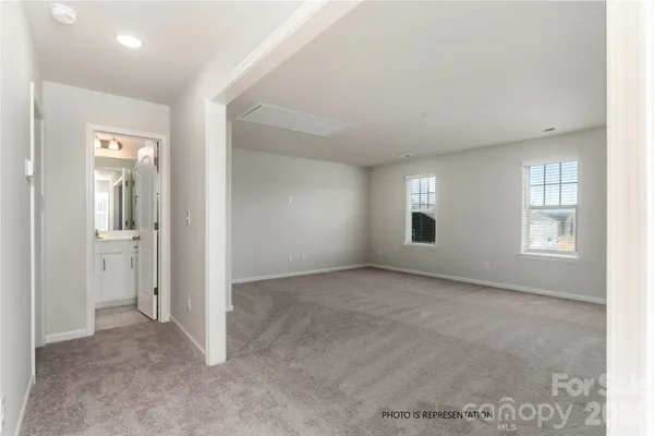 an empty room with windows and bathroom view