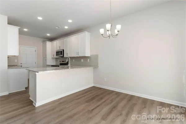 a view of kitchen with granite countertop cabinets and wooden floor