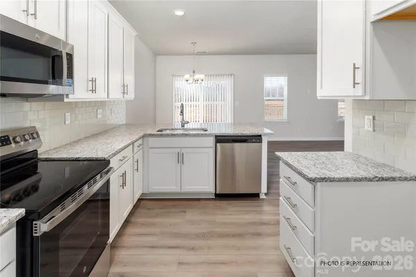a kitchen with stainless steel appliances granite countertop a sink stove and microwave