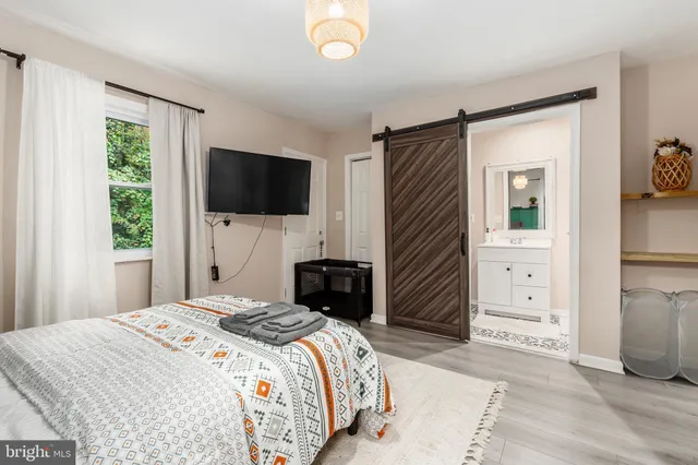 a bedroom with bed and flat screen tv