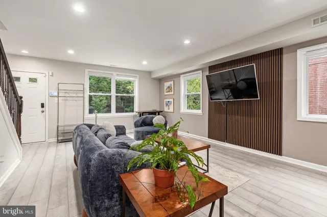 a living room with furniture and a wooden floor