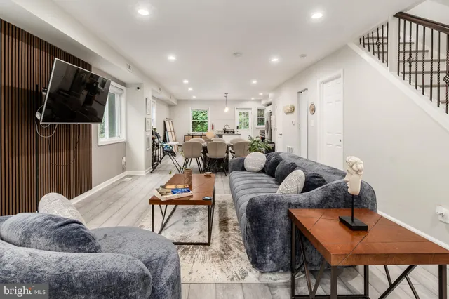 a living room with furniture tv and wooden floor