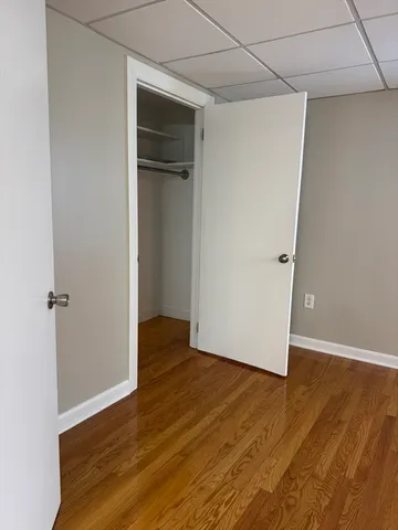 an empty room with wooden floor and closet