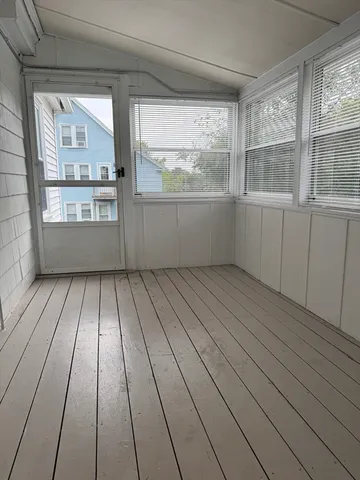 a view of empty room with wooden floor and windows