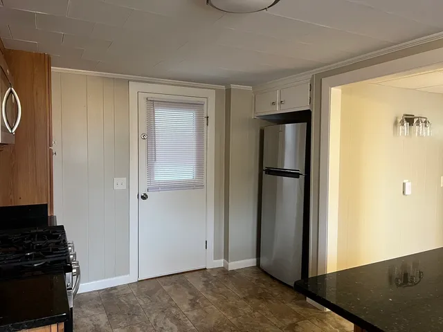 a view of a refrigerator in kitchen and wooden floor