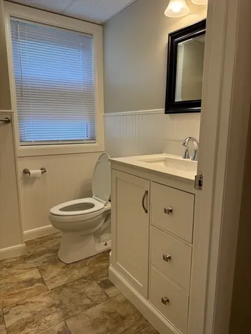 a bathroom with a toilet sink and mirror