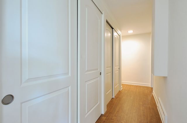 a view of a hallway with wooden floor