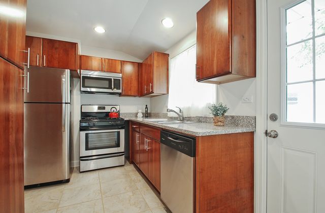a kitchen with stainless steel appliances granite countertop a refrigerator sink and microwave