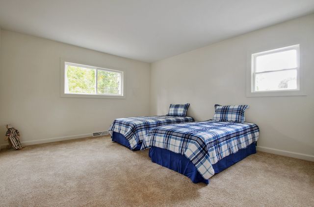 a bedroom with two bed and a window