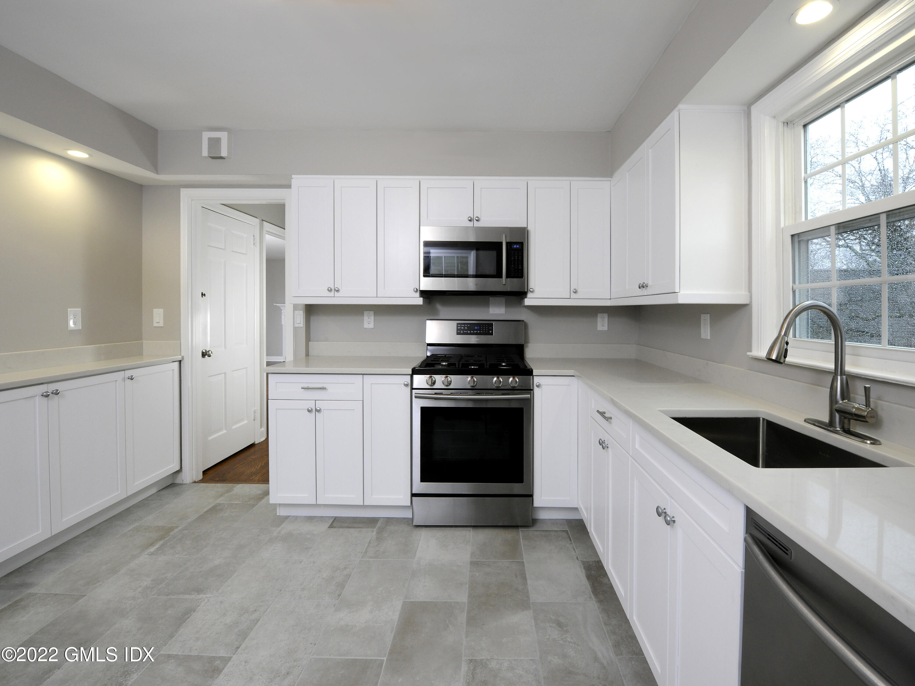 7 Butler Street Cos Cob, CT 06807 - Photo 3 of 18 a kitchen with granite countertop white cabinets and stainless steel appliances