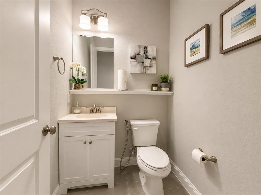 8235 Snapdragon Way Dallas, TX 75252 - Photo 4 of 29 Powder room featuring a white single-sink vanity with a light-toned countertop, a wall-mounted mirror, and a two-light vanity fixture