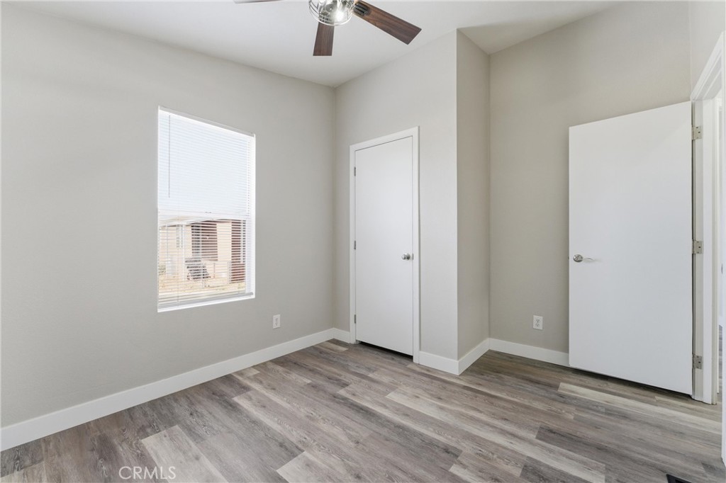 20843 Waalew Road, Unit C125 Apple Valley, CA 92307 - Photo 20 of 38 an empty room with wooden floor cabinet and windows